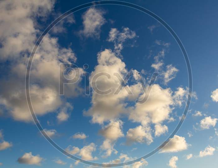 Striking Fluffy Clouds In The Blue Sky. Background For Designers