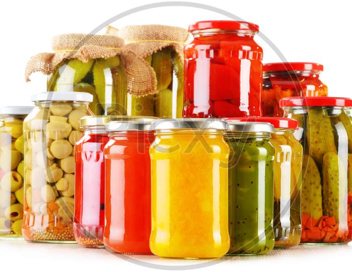 Composition with jars of pickled vegetables isolated on white. Marinated food