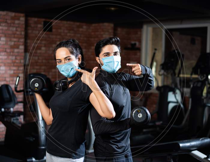 Indian Asian Young Couple Wears Face Mask And Working Out In The Gym