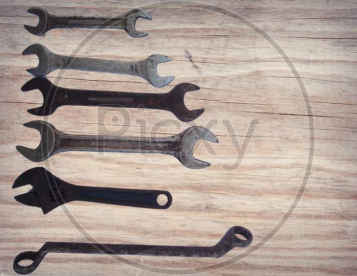 Various Types Of Wrench And Adjustable Wrench Isolated On Wooden Background.