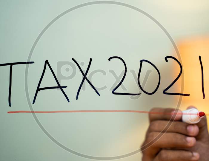 Hands Marking Line On Tax 2021 Test Written On Glass - Concept Of New Year 2021 Tax Pay And Return Concept