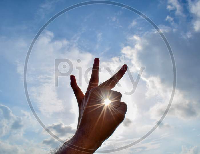 Hand gesture towards sun