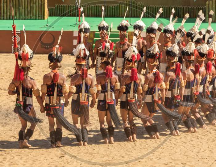 A group of naga tribesmen dressed in their traditional attire dancing
