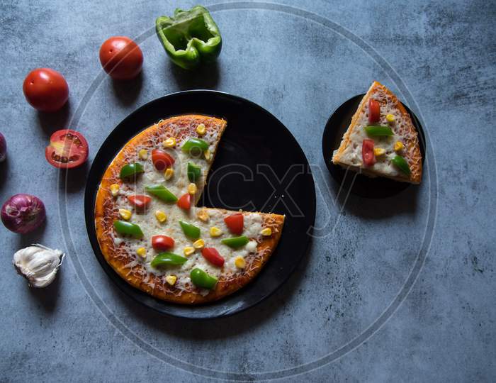 View from above of  pizza and a slice of pizza served on a plate