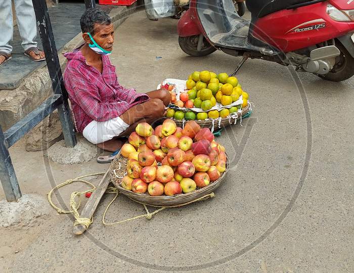 An old man selling fruits at roadside in vijayawada