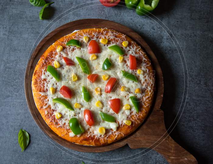 Vertical top view of margherita pizza with vegetables and herbs