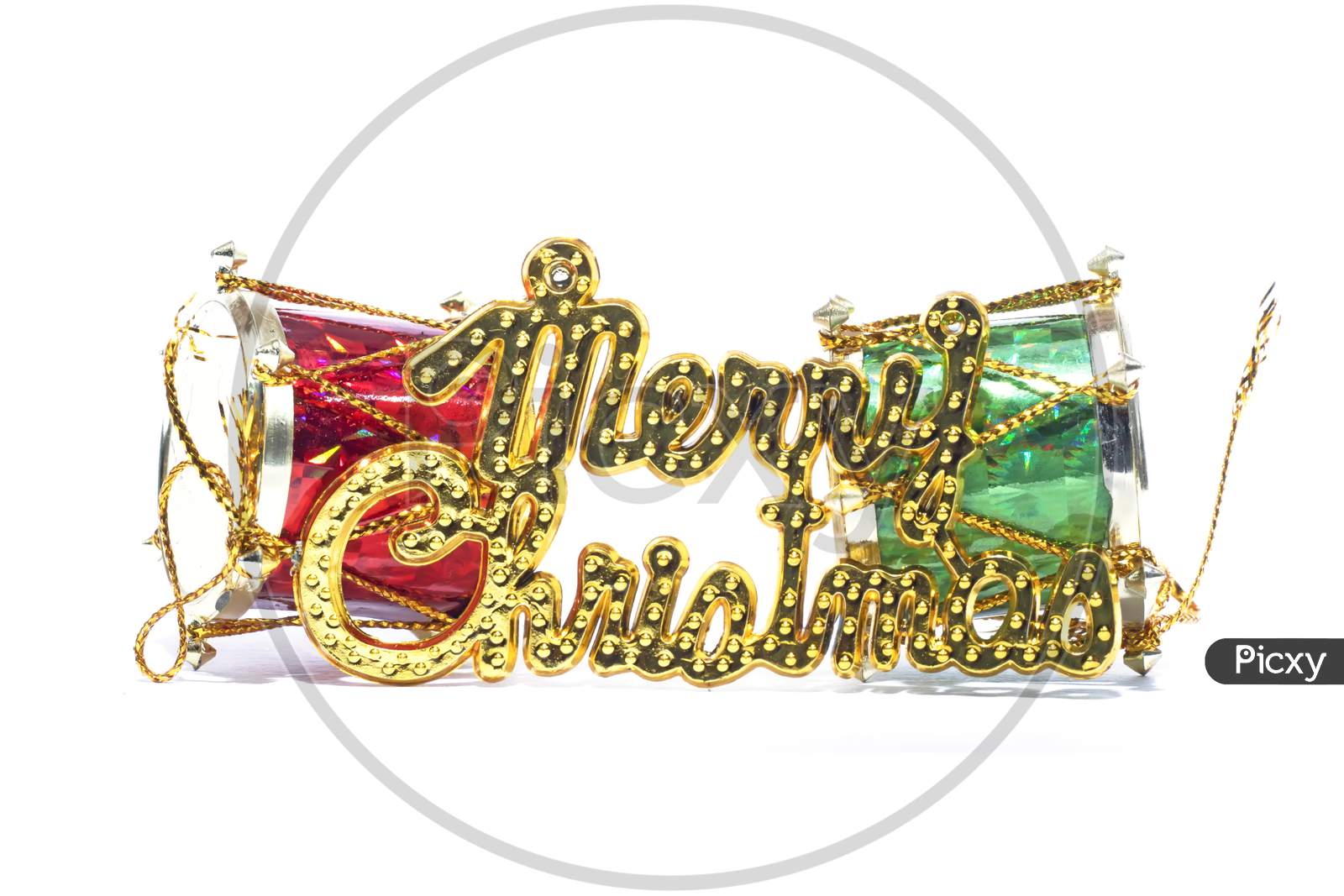 Merry Christmas Golden Text With Red And Green Drum Against The White Background