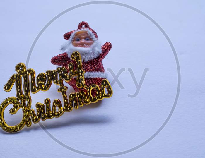 Merry Christmas Gold Text And Santa Claus Isolated On White Background Or Snow Background