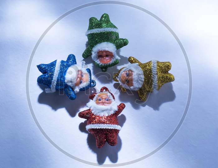 Multi-Colored Santa Claus With Sunlight Rays On A White Or Snow Background. Top View. Copy Space.
