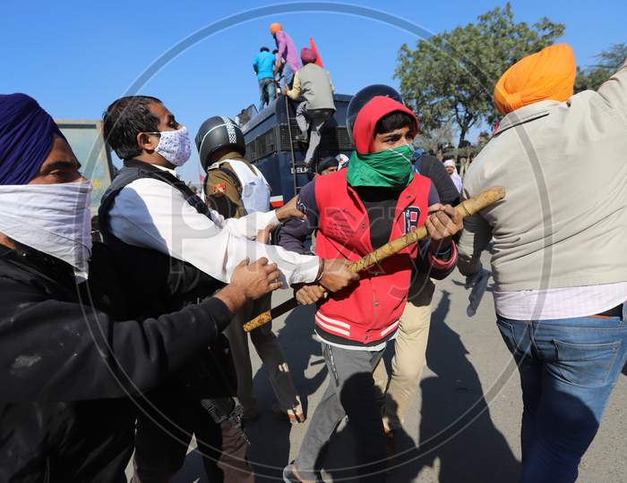 Police block a street to impede farmers from marching to New Delhi. Farmers are protesting against new farm laws that they fear will reduce their earnings and give more power to large retailers, at the Delhi-Haryana border in Singhu on November 27, 2020.