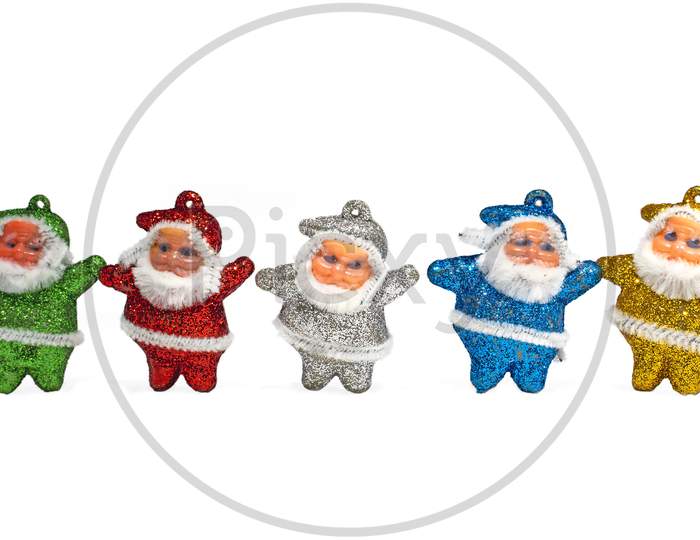 Multi-Colored Santa Claus Decorations On White Background. Copy Space