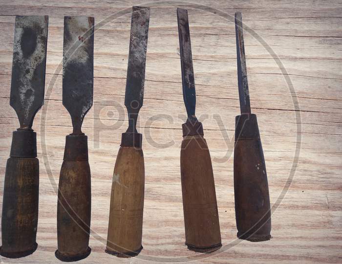 Different Types Of Chisel Isolated On Wooden Background.