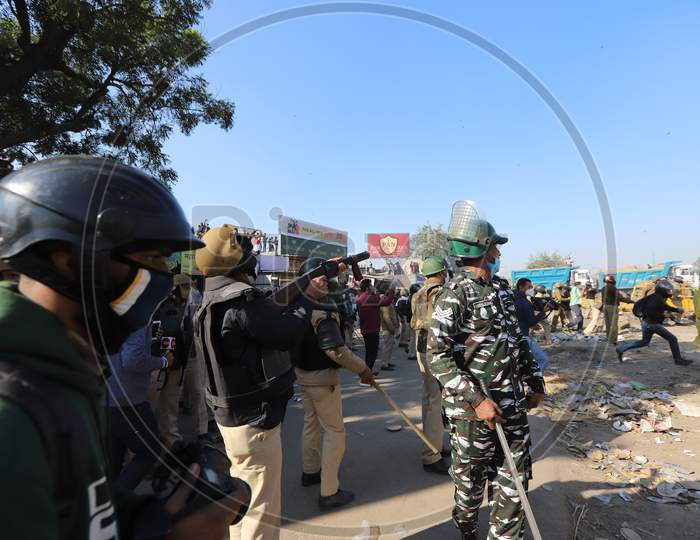 Police block a street to impede farmers from marching to New Delhi. Farmers are protesting against new farm laws that they fear will reduce their earnings and give more power to large retailers, at the Delhi-Haryana border in Singhu on November 27, 2020.