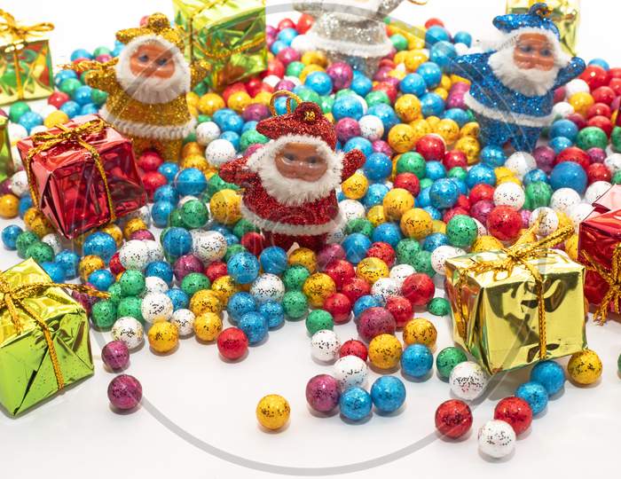 Santa Claus With Colorful Balls And Gift Boxes On White Background.