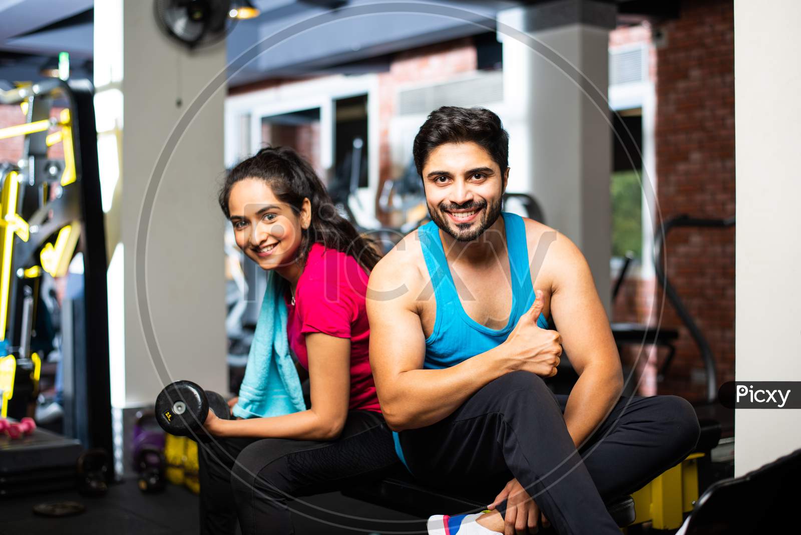 Portrait Of Indian Asian Young Couple Working Out Together In Gym, Training With Fitness Equipments