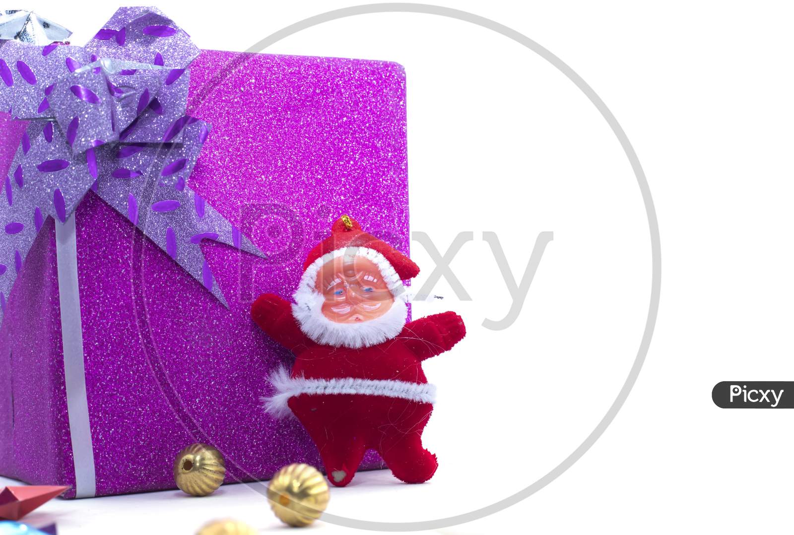 The Statue Of Santa Claus With The Large Gift Box Is Isolated On A White Background