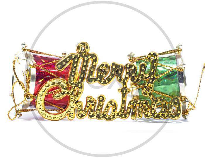 Merry Christmas Golden Text With Red And Green Drum Against The White Background