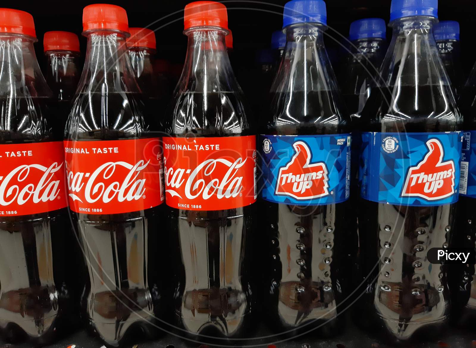 bottles of coca cola and thums up in supermarket shelf