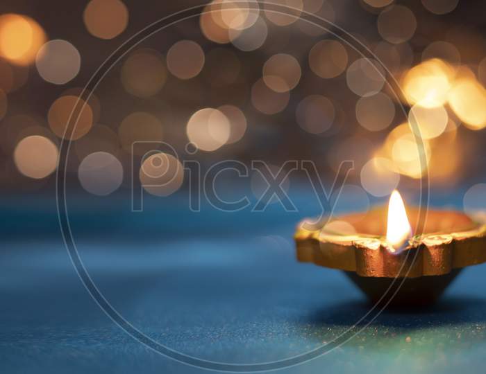 Diya Lamps On A Reflective Base With Glittering Bokeh