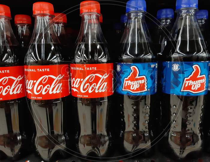 bottles of coca cola and thums up in supermarket shelf