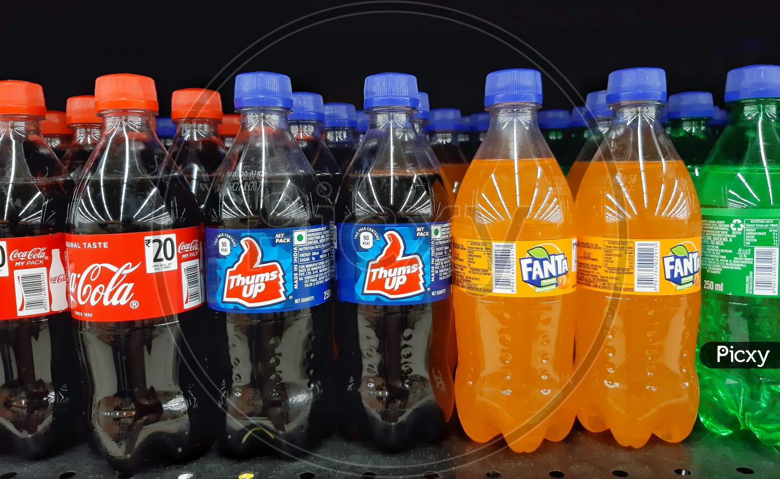 bottles of coca cola and thums up and fanta in supermarket shelf