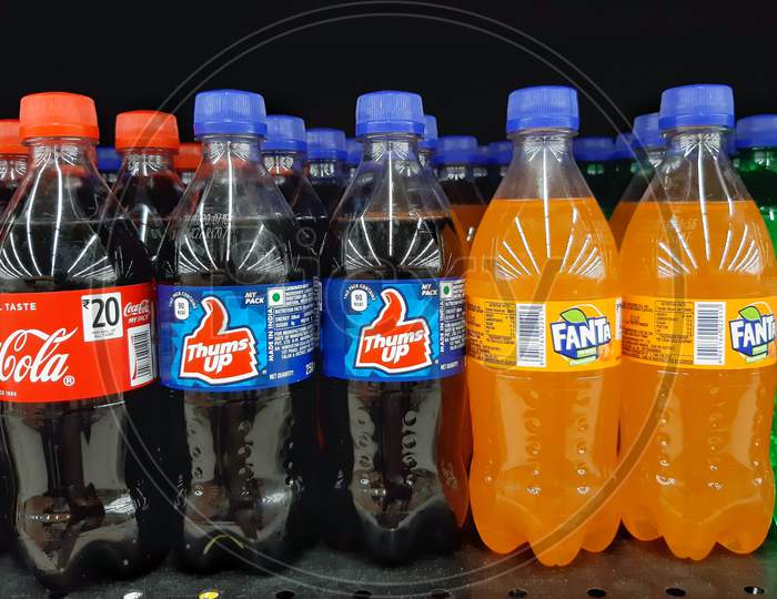 bottles of coca cola and thums up and fanta in supermarket shelf