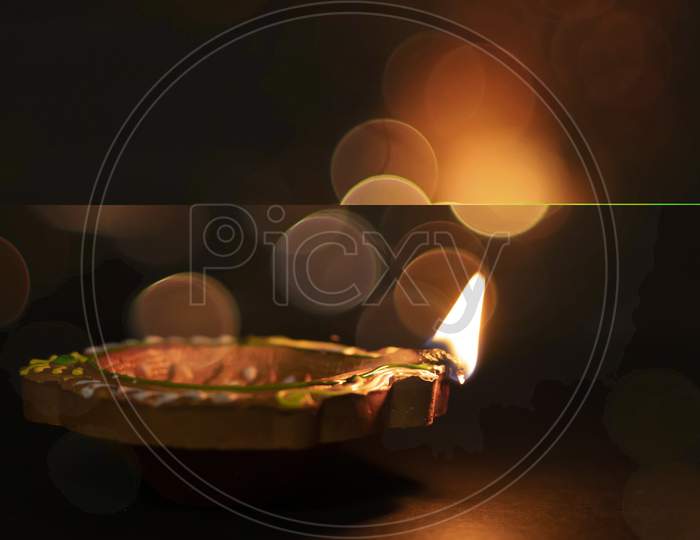 Diwali Celebration - Diya Lamp With Glitter Light Background