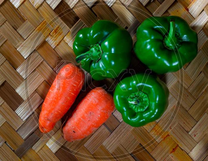 Fresh Green Capsicum And Carrot Vegetable On A Bamboo Background