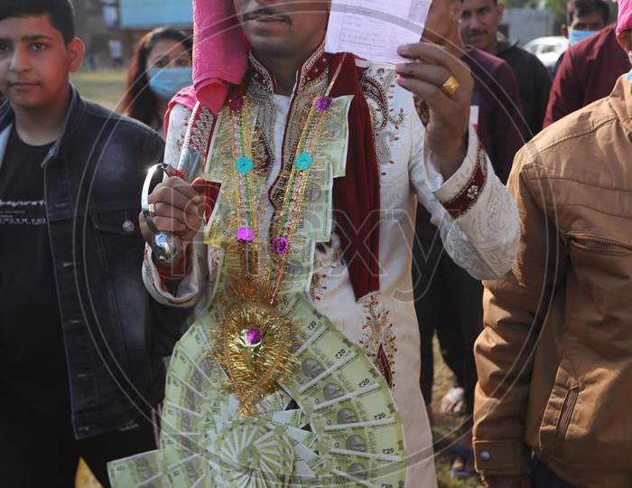 Newly married Mangat Ram, 27, shows his ink marked finger after casting his ballot during the first phase of the District Development Council (DDC) and Panchayat by-elections at a polling station in Akhnoor near Jammu on November 28, 2020.