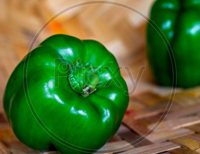 Fresh Green Capsicum Vegetable On A Bamboo Background