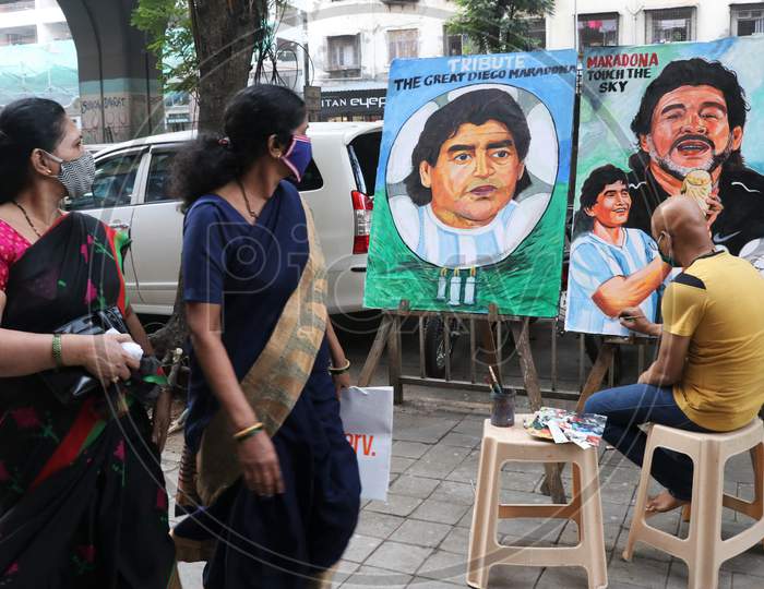 An artist paints a tribute to late Argentine soccer legend Diego Maradona, on a street in Mumbai, India in November, 2020.