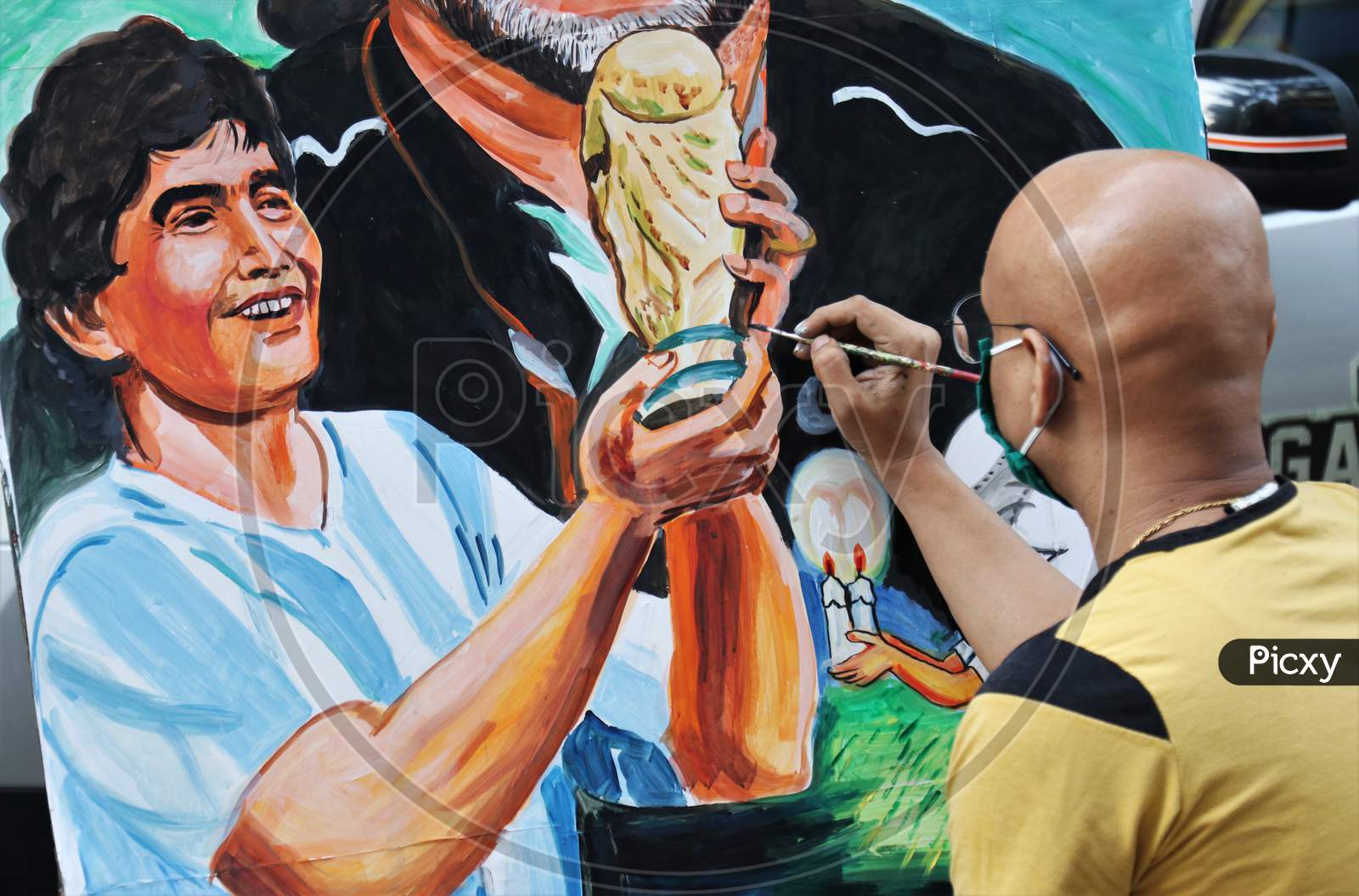 An artist paints a tribute to late Argentine soccer legend Diego Maradona, on a street in Mumbai, India in November, 2020.