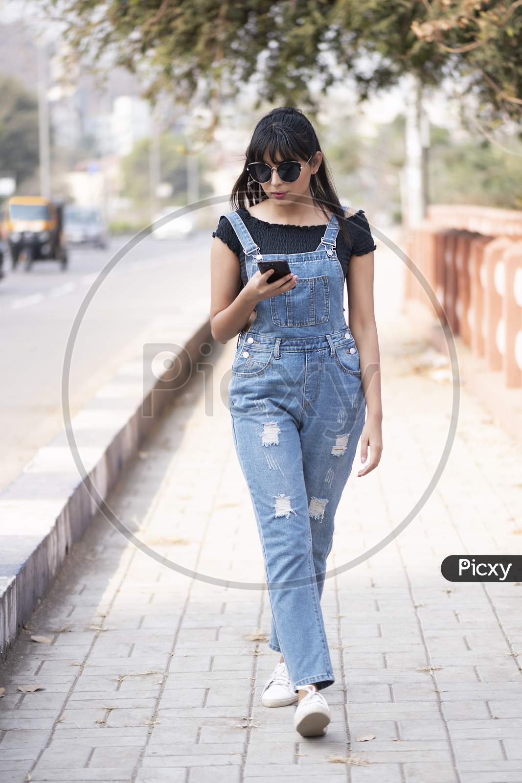 Lifestyle of young Indian model wearing denim jump suit and walking on streets