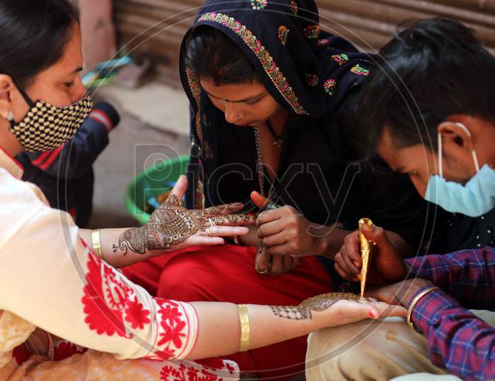Women get henna designs on their hands on the eve of Karva Chauth festival in Jammu,3 November,2020.