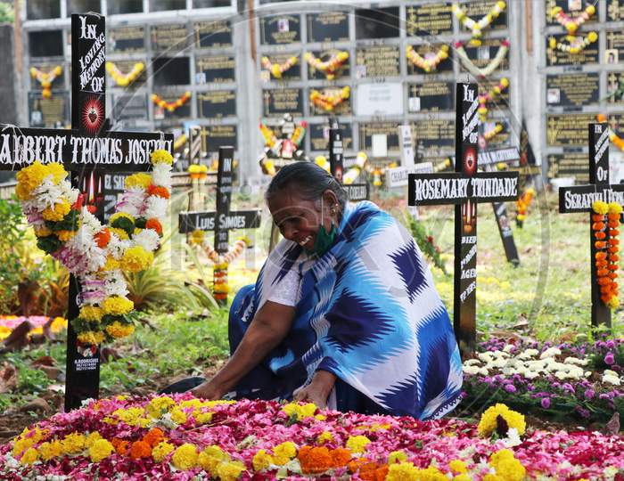 A woman is seen mourning over a deceased relative at a graveyard on All Souls Day in Mumbai, India, November 2, 2020.