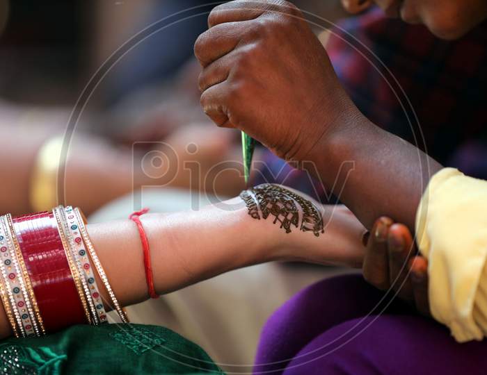 Women get henna designs on their hands on the eve of Karva Chauth festival in Jammu,3 November,2020.