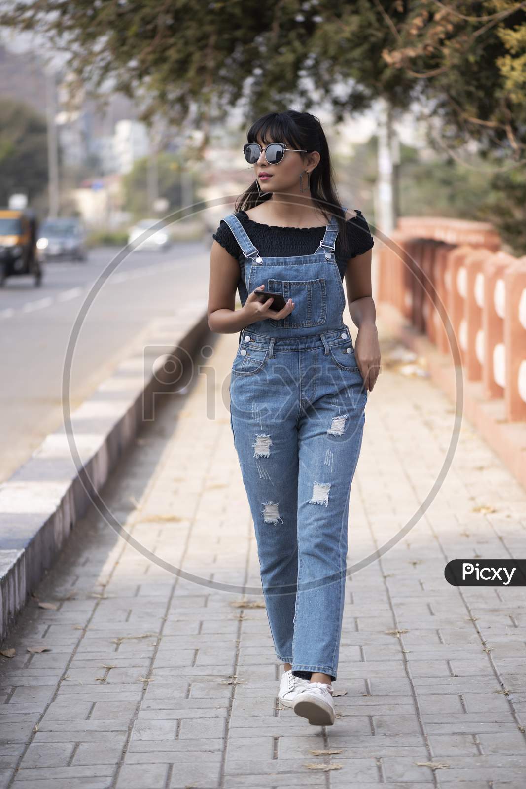 Lifestyle of young Indian model wearing denim jump suit and walking on streets