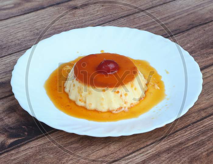 Delicious Caramel Cheesecake With Cherry On White Plate