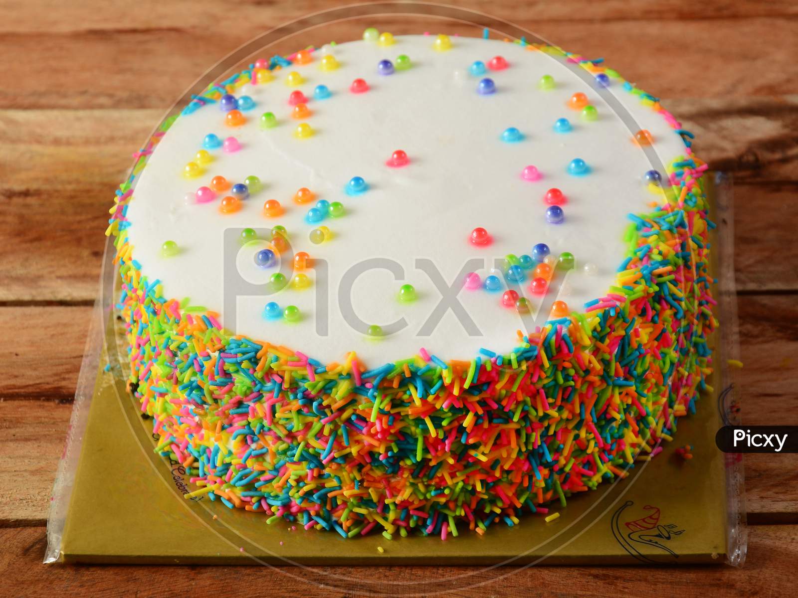 Freshly Made Rainbow Cream Cake On Wooden Table. Selective Focus