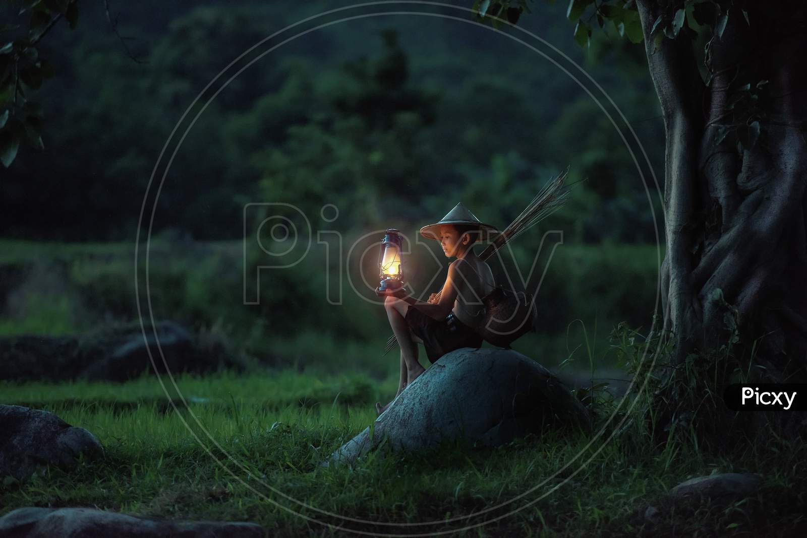 A little boy sitting with a lamp