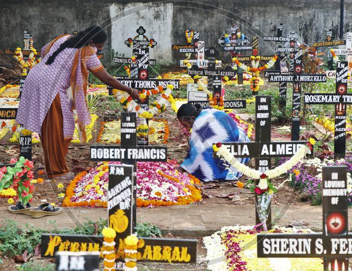 Women offer prayers to a deceased relative at a graveyard on All Souls Day in Mumbai, India, November 2, 2020.