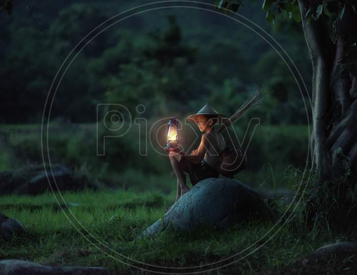 A little boy sitting with a lamp
