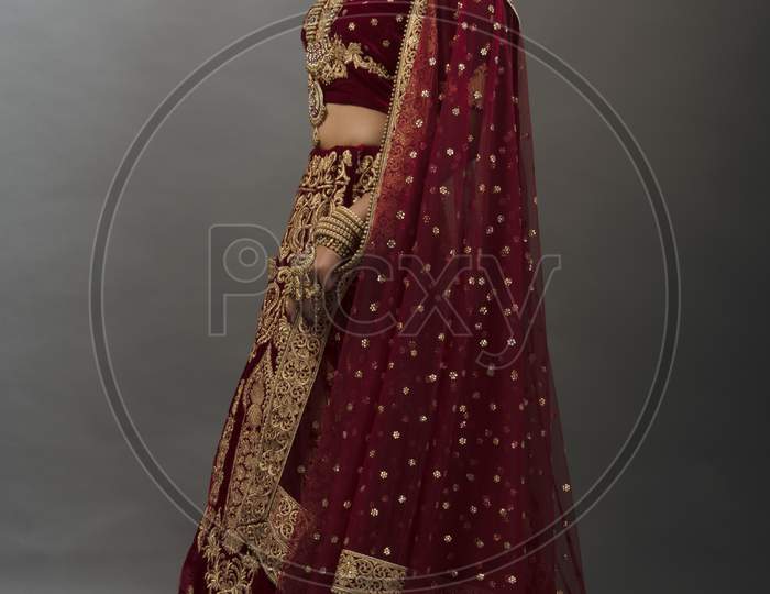 Young Indian lady in ethnic bridal wear, jewelry and make-up