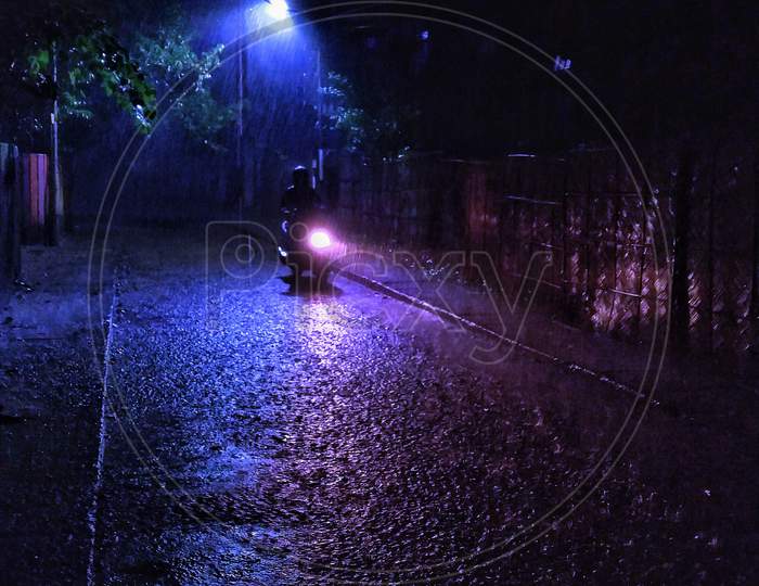 Man riding bike on monsoon night