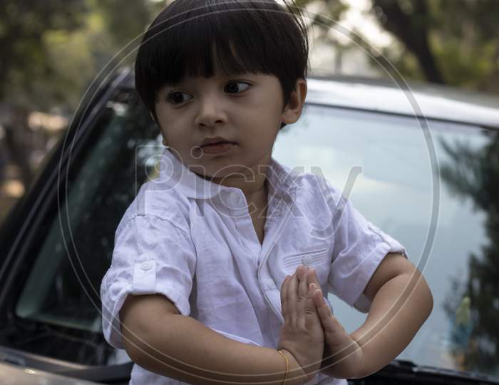 Indian Cute Boy Sitting On Car Bonnet