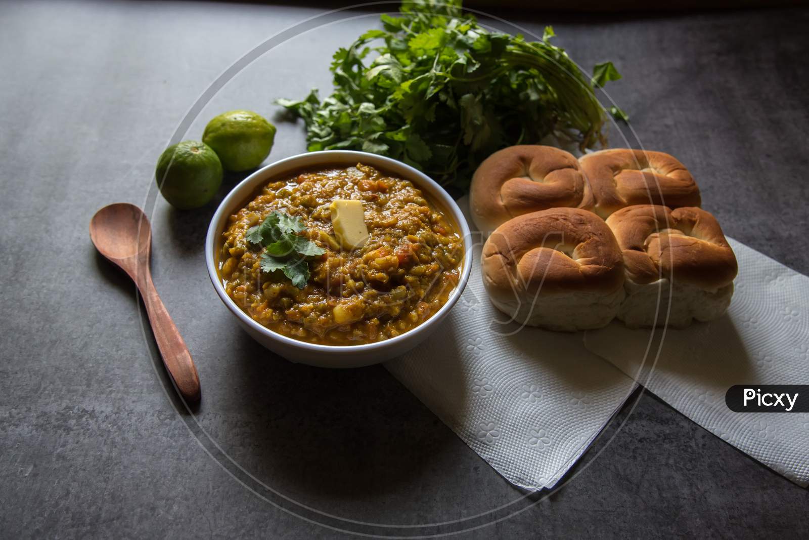 Spicy Indian dish pav bhaji or bread with masala curry along with food ingredients