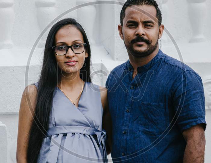 Pregnant Couple Portraiture In Front Of White Walls In Galle, Two Beautiful Models Posing Close To Each Other.