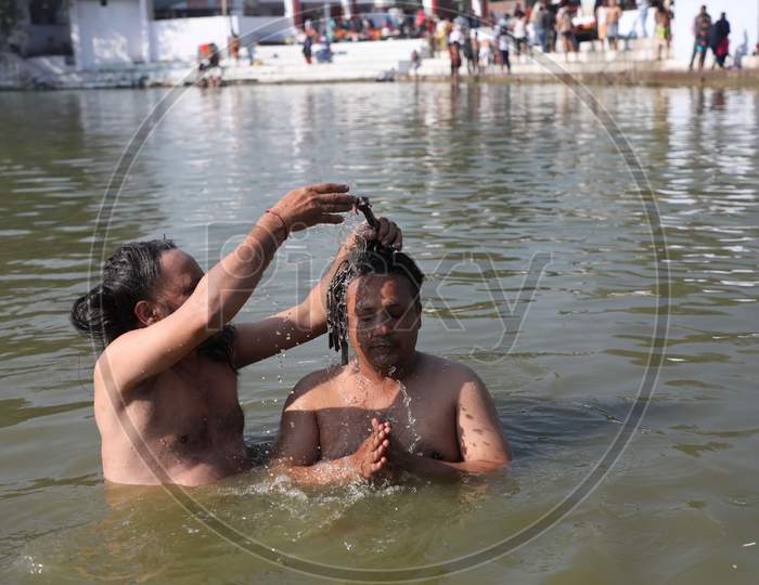 Hindu devotees take a holy dip in the pond during the annual farmer fair at Shama Chak Jhiri, some 22 km from Jammu,30,November,2020.