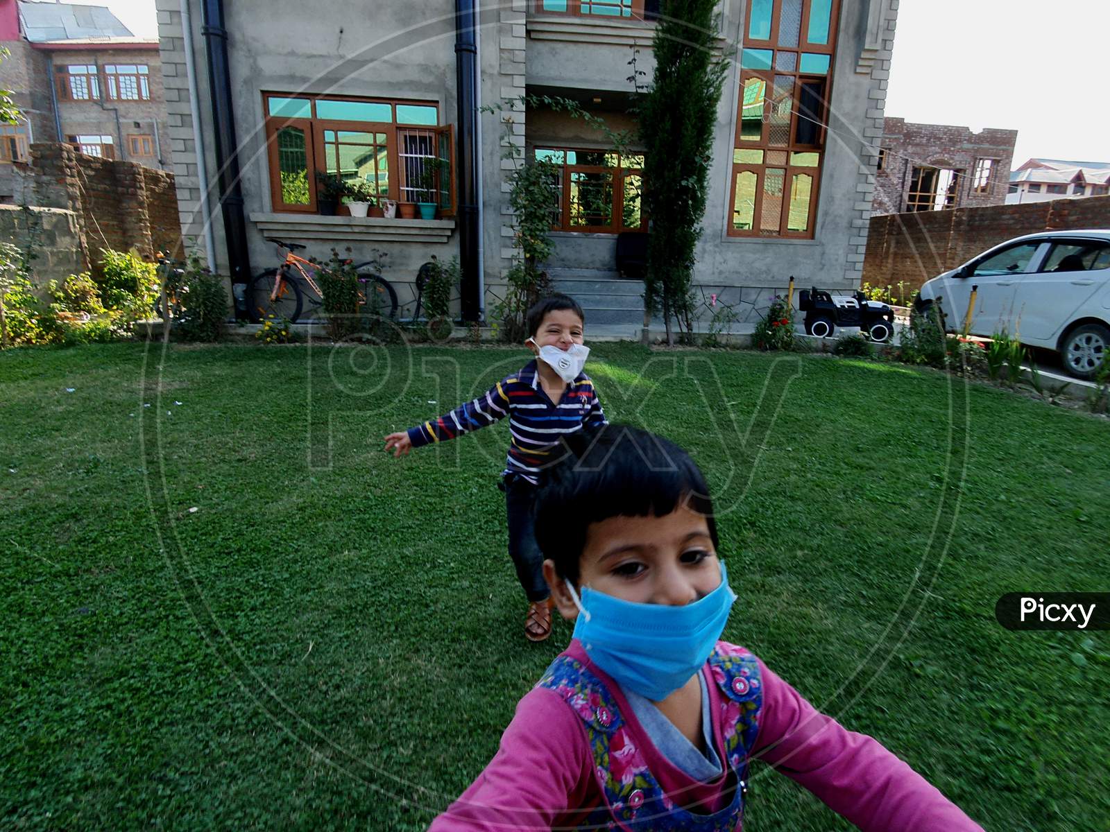 Masked Handsome Kids Are Playing Running Enjoying And Smiling At Home Park During Coronavirus Lockdown.