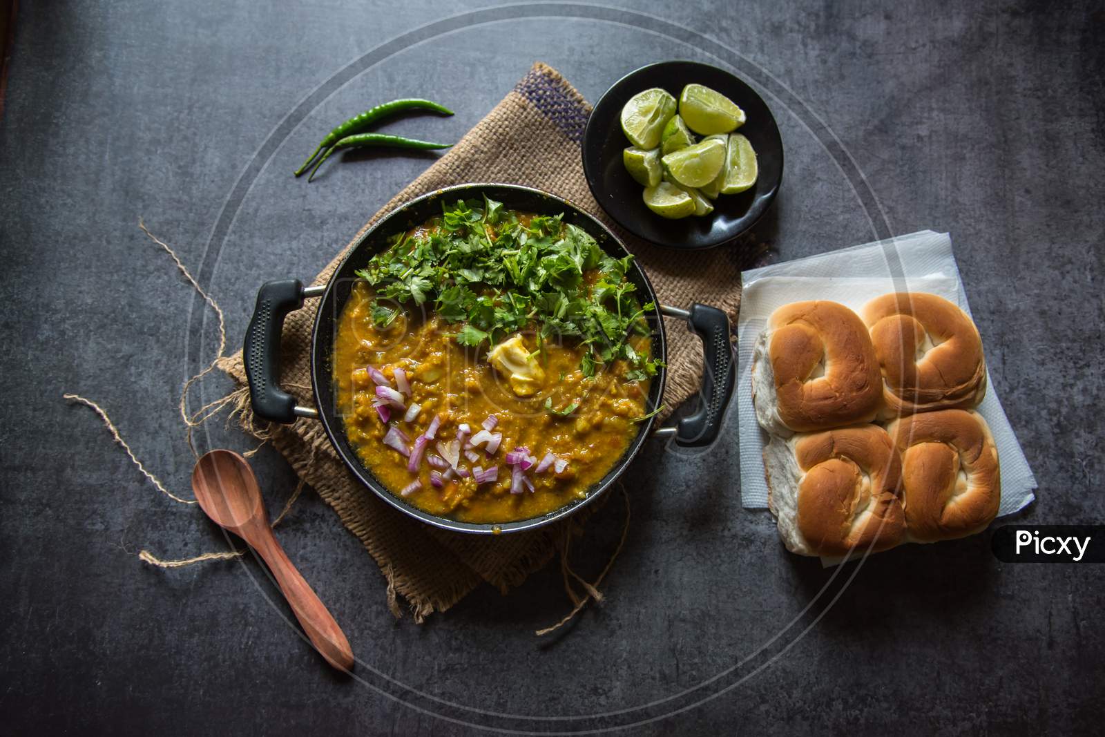 Indian snacks pav bhaji or bread masala curry in a black pan